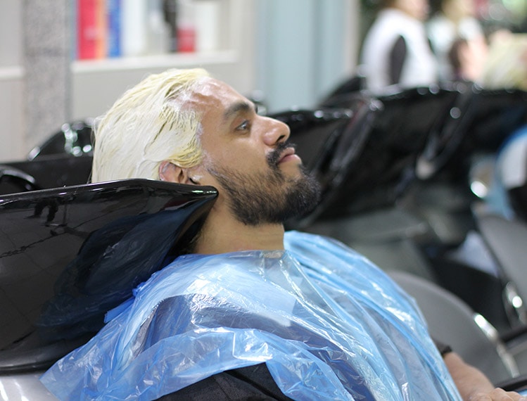 homme barbu en train de se faire teindre les cheveux chez le coiffeur